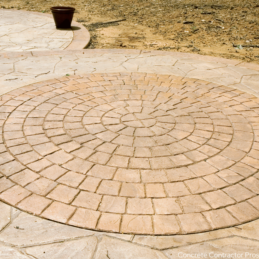 Circle patterned stamped concrete on patio in a backyard under construction.